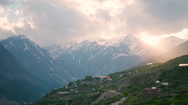 4K Landscape shot of orange sun rays through the clouds during the sunset as seen from Khangsar village in Lahaul and Spiti district, Himachal Pradesh, India. Scenic sunset background.