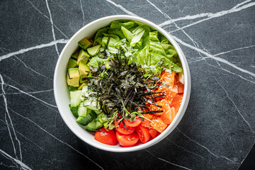 Fototapeta premium Colorful and fresh salad bowl featuring crisp greens and vibrant vegetables on a dark marble surface