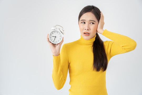 Shocked Asia young woman looking at clock alarm, lady is late appointment or work or class study, overslept, difficulty get up in mornings, time worried, not on time, sleepy, over due, Hurry up time