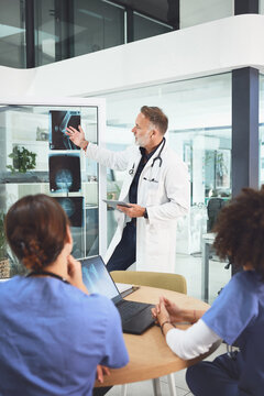 People, doctor and nurse with xray presentation with tech for meeting, planning or procedure in hospital. Group, healthcare workers or team with laptop, documents and collaboration for bone treatment
