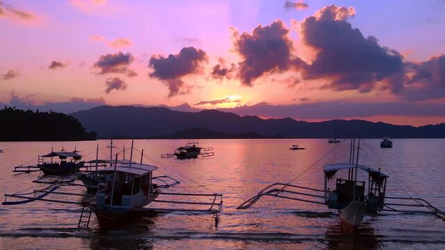 Traditional bancas in Port Barton bay during sunset. Great aerial view drone