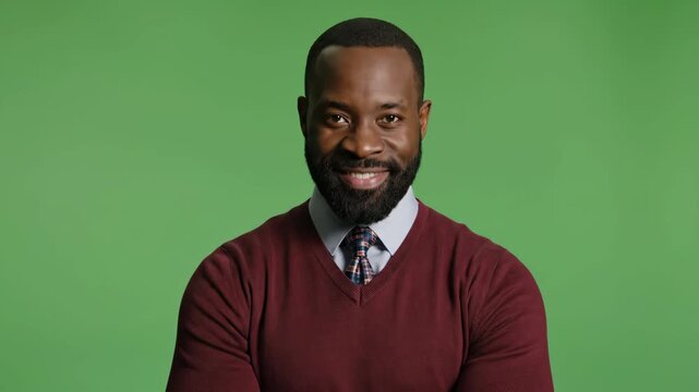 Smiling man with beard in professional attire against green background
