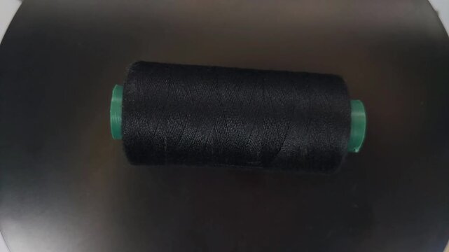 sewing thread spool rotating in top-down view with smooth motion and clean composition.