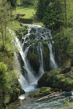A powerful waterfall cascades over mossy rocks into the Slunjcica river in the picturesque historic village of Rastoke near Slunj