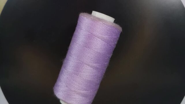 sewing thread spool rotating in top-down view with smooth motion and clean composition.