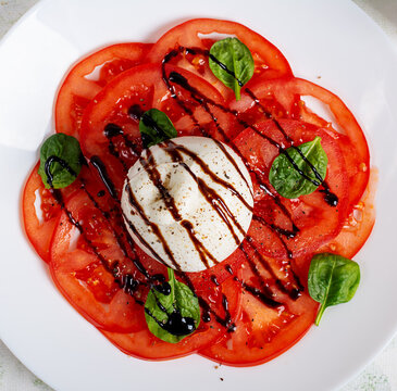 Burrata Cheese with Fresh Tomatoes and Balsamic Glaze Close Up. Top View. Texture