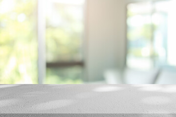 Naklejka premium abstract blurred garden view form living room window with modern plain concrete table counter background for show , promote ,design banner ads on display concept