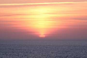 Fototapeta premium Golden Sunset Over Atlantic Ocean in Algarve Portugal with Calm Sea Horizon