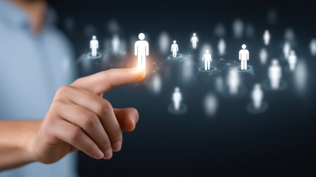 Close-up of hand pressing a glowing human icon on a virtual interface, with other small human figures connected by lines, representing selection, networking, and recruitment