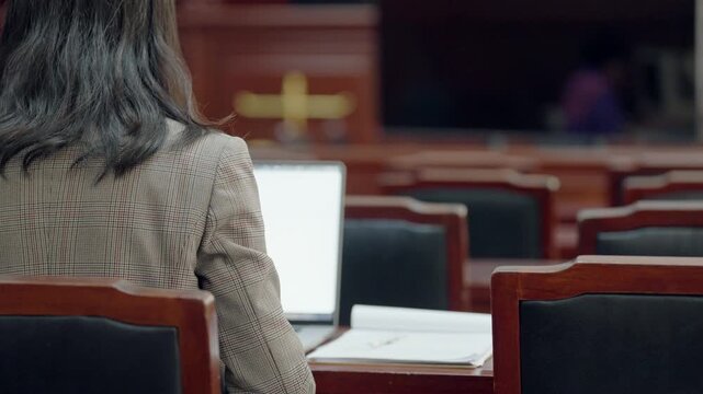 Female lawyer working seriously making legal decisions on documents. Concept of justice, responsibility, law practice, and corporate legal decision-making in professional setting.