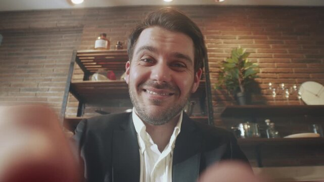 Friendly man setting webcam, Casual professional man in cozy cafe finetunes his remote meeting camera setup