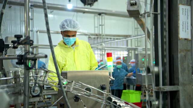 The foreman is inspecting the can conveyor line and recording data at a fish canning factory