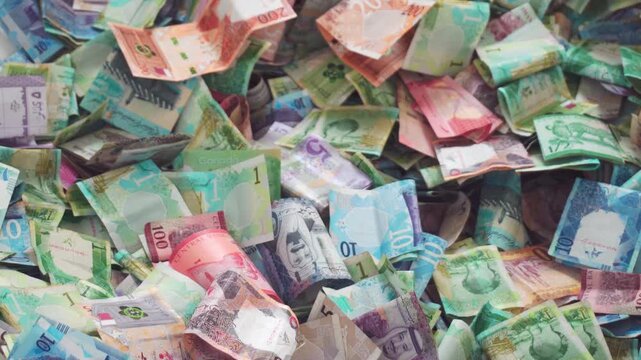 Close up vibrant pile of Qatari Riyal banknotes from the fifth series. Various colorful denominations 1, 10, and 50, showcasing Qatars modern currency and heritage. Charity box. Fundraiser. Lottery