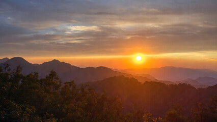 Fototapeta premium Golden Sunrise Over Ancient Mountain Landscape With Silhouetted Walls