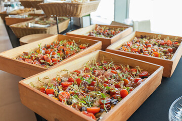 Catering with meats, fruits, cheeses and sandwiches. An assortment of cold cuts and canapes on wooden skewers