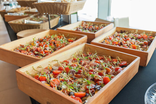Catering with meats, fruits, cheeses and sandwiches. An assortment of cold cuts and canapes on wooden skewers