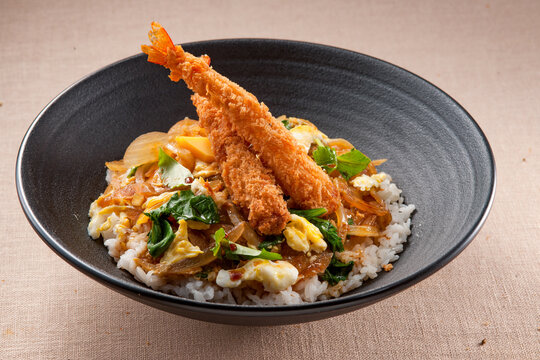 Japanese style shrimp tempura rice bowl, Ebidon, with fried prawns and egg garnish in a black bowl.