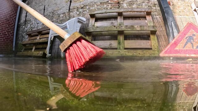 Video cleaning a deck with water and a hard broom.