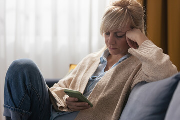Woman feeling worried receiving bad news on smartphone