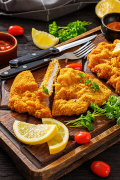 Crispy meat schnitzel served on wooden cutting board