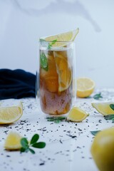 Fototapeta premium Refreshing iced tea with lemon slices and fresh mint on marble surface for summer healthy lifestyle advertising food blog and organic.