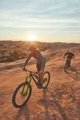 Fototapeta premium Mountain biking, ride and fitness with men in nature for race, extreme sports and adventure. Sky space, training and journey with people or friends on bicycle outdoor cycling, exercise and flare