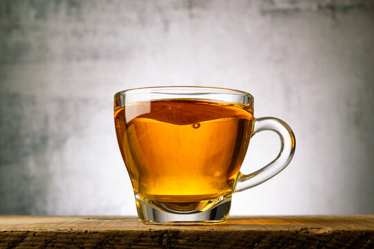 Glass cup of tea on wooden table.