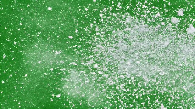 A vibrant green background is speckled with clusters of white, powdery substances