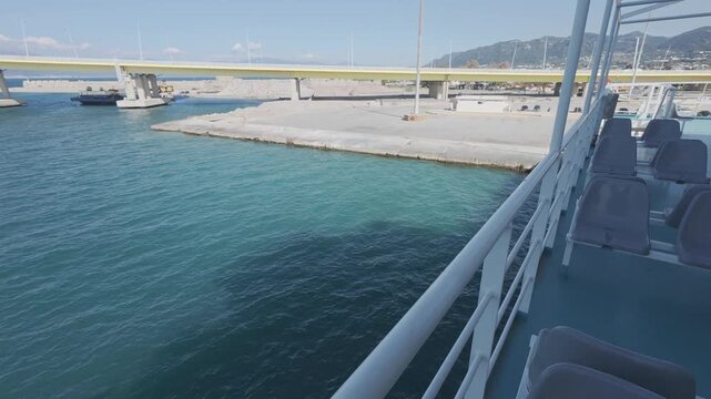 Quiet harbor seen from ferry deck railing in early morning light