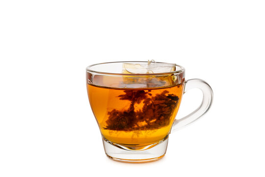 Glass cup of tea with tea bag inside, isolated on white background.