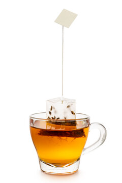 Glass cup of tea with tea bag inside, isolated on white background.