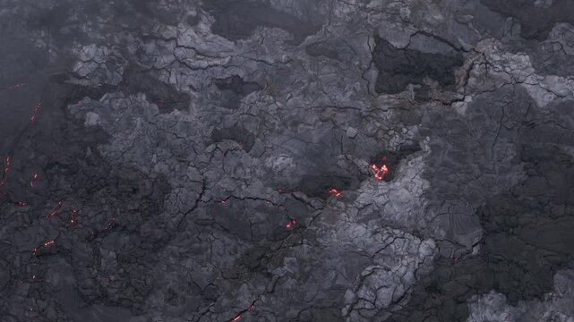 Aerial view of Piton de la Fournaise's stark volcanic landscape, where fiery lava veins crawl through cracked earth, Piton de la Fournaise, Saint-Benoit, Reunion.