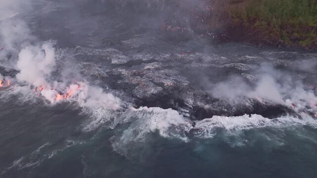 Aerial view of lava flow from Piton de la Fournaise, with smoke rising and contrasting with dark volcanic rock, Piton de la Fournaise, Saint-Benoit, Reunion.