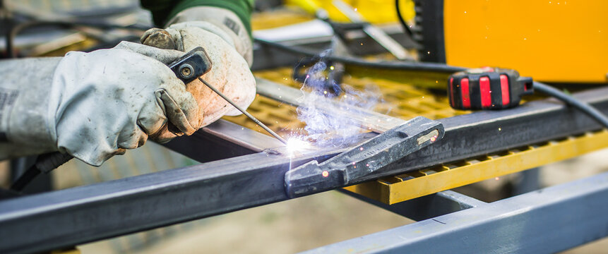 Craftsman's focused hands ignite brilliant sparks, expertly fusing sturdy metal in a dynamic industrial workshop