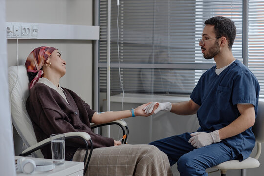 Doctor supporting patient during chemotherapy infusion at clinic