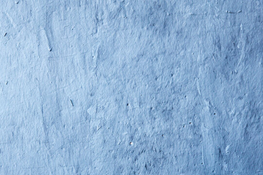Blue painted concrete wall texture with visible brush strokes and drips.