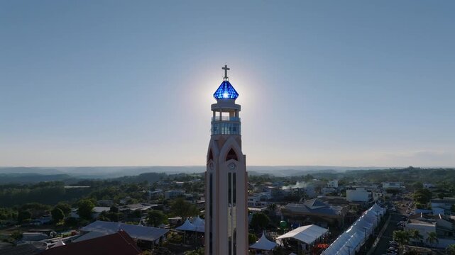 Church viewpoint tower aligns with the rising sun above Ametista do Sul, illuminating the amethyst-shaped crown and cross, captured in D-Log with 10-bit color using a Hasselblad sensor.