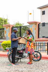 Obraz premium Delivery driver handing package to a woman making mobile payment