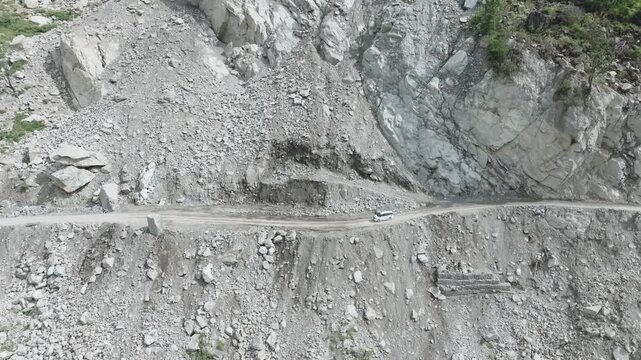 Wide aerial view of a massive rockfall and landslide blocking highway traffic in Himachal Pradesh