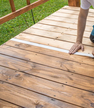 Wooden deck gleams under sunlight, freshly stained