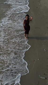 태국 방센 해변의 에메랄드빛 바닷가를 여유롭게 산책하는 젊은 여성의 뒷모습
