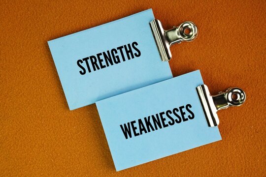 Colored paper with the words strengths and weaknesses. key interview topics designed to gauge self-awareness, honesty, and fit