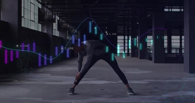 Stretching male athlete reaching ankle in loft, with hoodie, shoes, fitted pants, finance charts