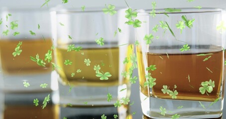 Featuring rightmost glass in trio of tumblers holding amber liquid on glossy table, clover decals © vectorfusionart