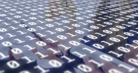 Fototapeta premium Overlaying binary digits covering office desk, team tapping laptop tablet stylus in business-casual