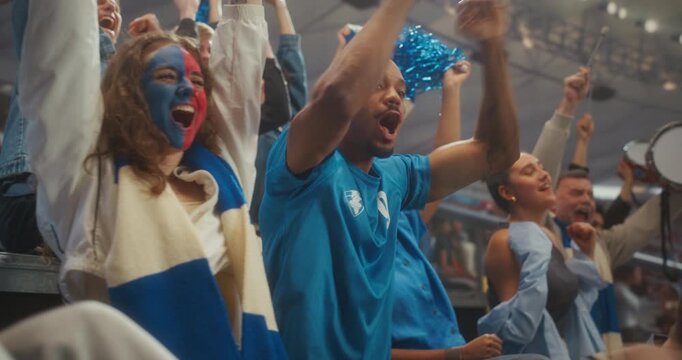 Close-up of Joyful Soccer Supporters in a Packed Stadium During a Professional International League Match, With a Smiling Young Black Couple in Clapping as the Crowd Celebrates Victory.