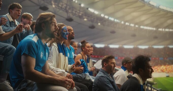 Diverse Happy Soccer Fans in Blue Jerseys Celebrate a Professional League Championship Match in a Packed stadium Cheering, Clapping and Smiling During an International Cup Event. Slow Motion