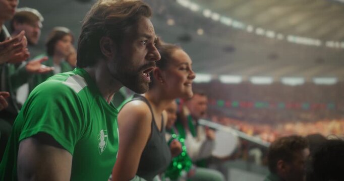 Devastated Sports Fans in Green React to a Painful Loss in  Stadium as Man Grabs His Head in Disbelief and Nearby Angry Supporters, Frustration, Despair of Losing Match and Game.