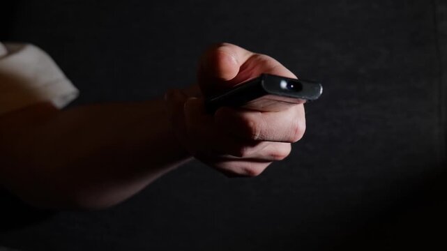 Person Browsing TV Channels With Remote Control Close-Up View