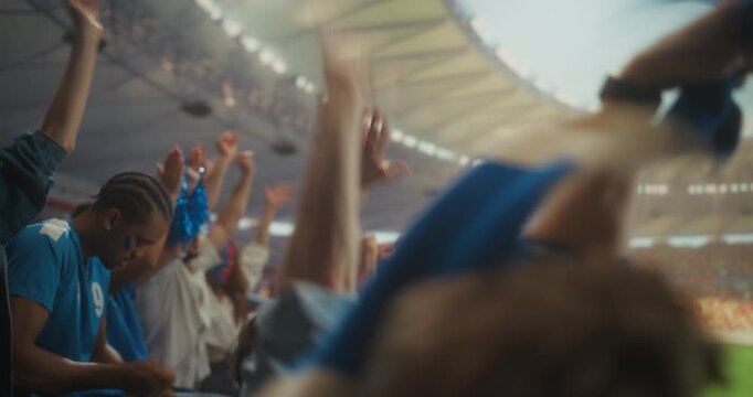 Side view Portrait of a Diverse Group of Soccer Supporters Celebrating in a Packed stadium With a Man in a Cap and Cheering Fans Raising Arms During a Professional League International Match.